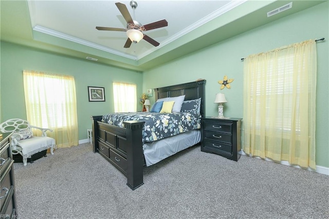 carpeted bedroom with baseboards, visible vents, ceiling fan, crown molding, and a raised ceiling