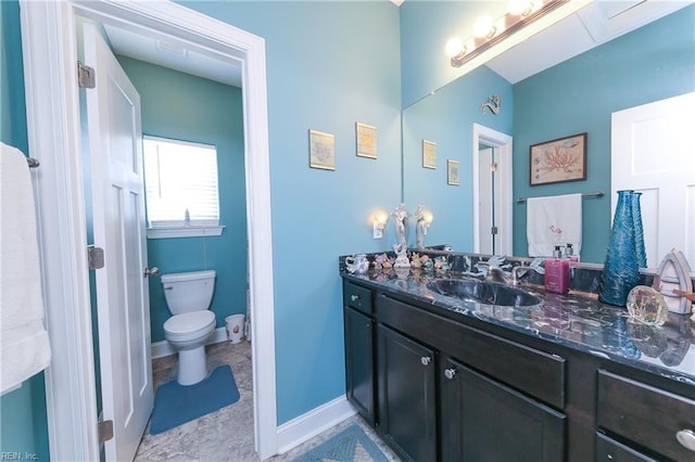 bathroom featuring baseboards, toilet, and vanity