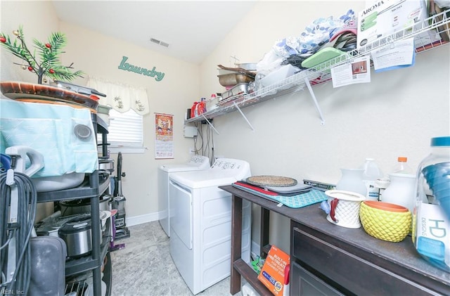 laundry room with washing machine and clothes dryer, visible vents, baseboards, light colored carpet, and laundry area