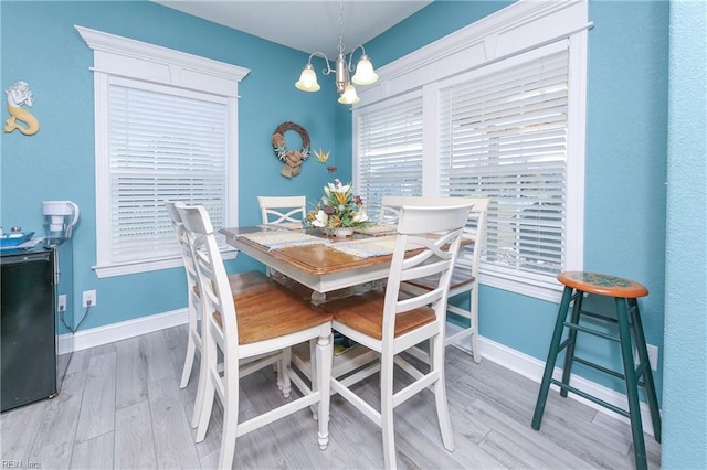 dining area with hardwood / wood-style floors and an inviting chandelier