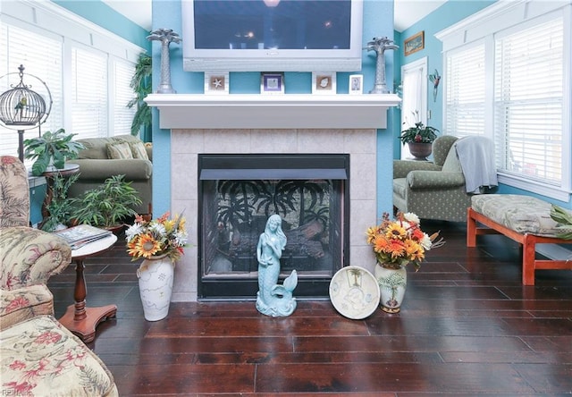 living area with a tile fireplace and wood-type flooring