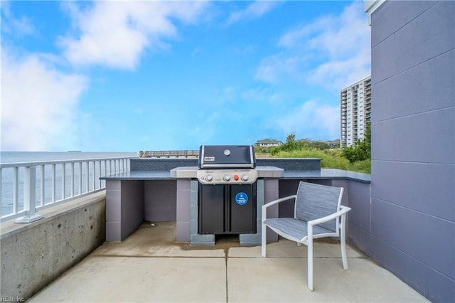 view of patio featuring grilling area, a balcony, and a water view