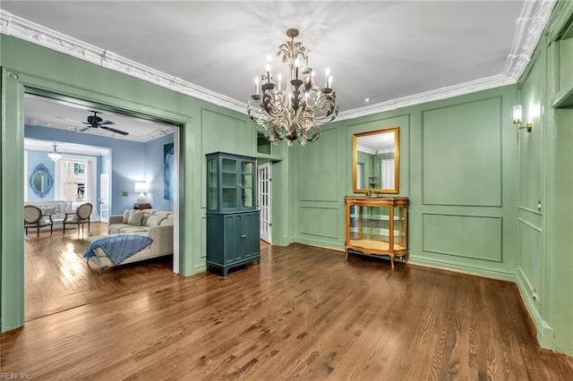 interior space featuring dark hardwood / wood-style flooring, ceiling fan with notable chandelier, and ornamental molding