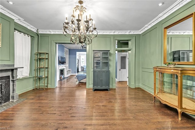 dining area with dark wood-type flooring, crown molding, and a chandelier