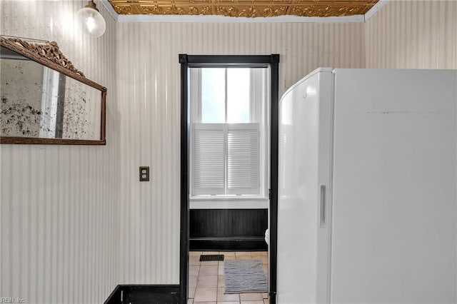 doorway to outside with tile patterned flooring and ornamental molding