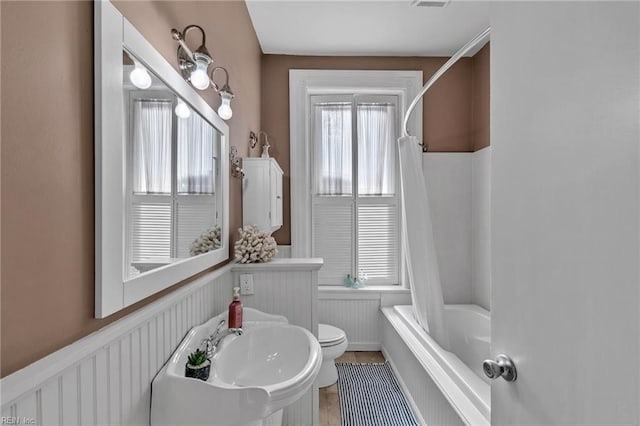 bathroom with shower / bath combo and toilet