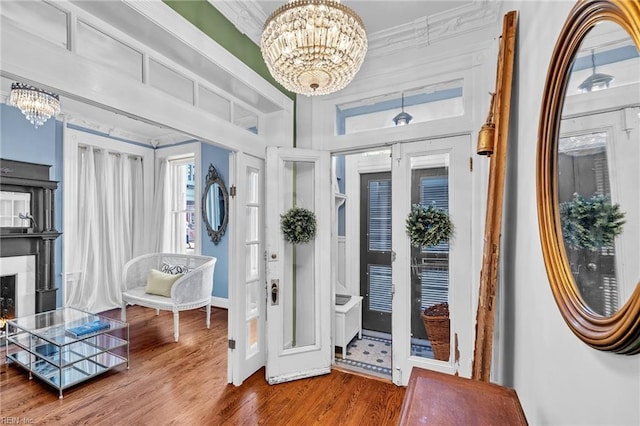 foyer entrance featuring crown molding, a chandelier, and hardwood / wood-style flooring