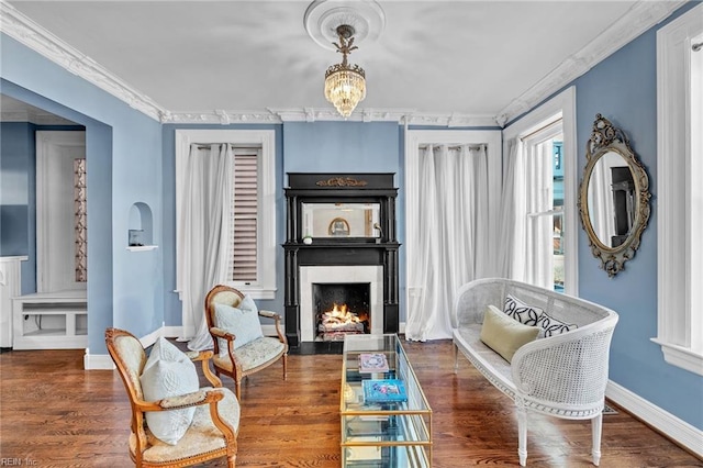 sitting room featuring dark hardwood / wood-style flooring, an inviting chandelier, and crown molding