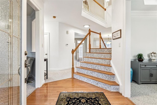 stairway featuring hardwood / wood-style floors and crown molding