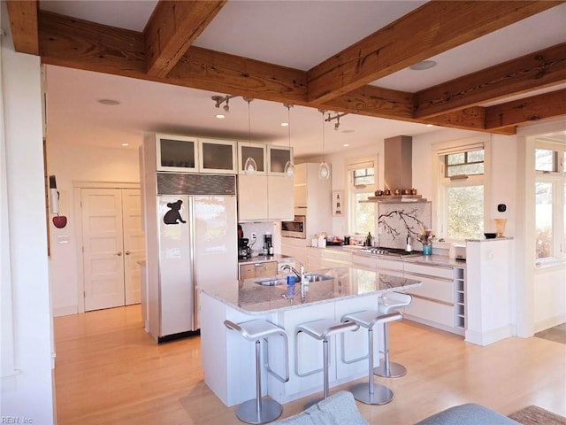 kitchen with white cabinets, a center island, paneled built in fridge, and sink