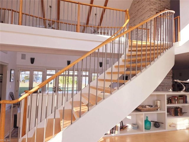 stairs with french doors and a high ceiling