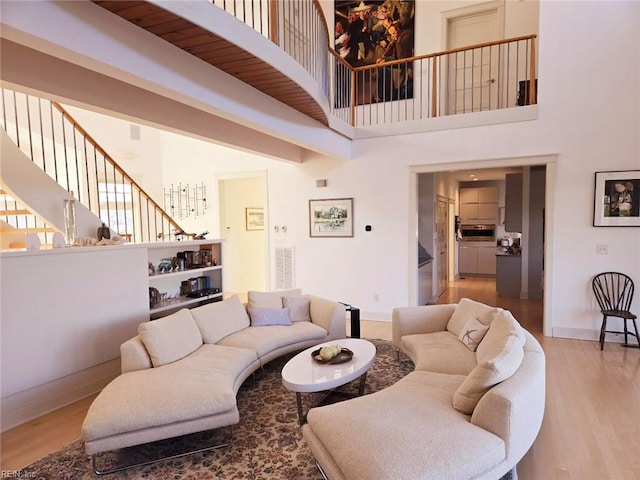 living room featuring hardwood / wood-style floors and a towering ceiling