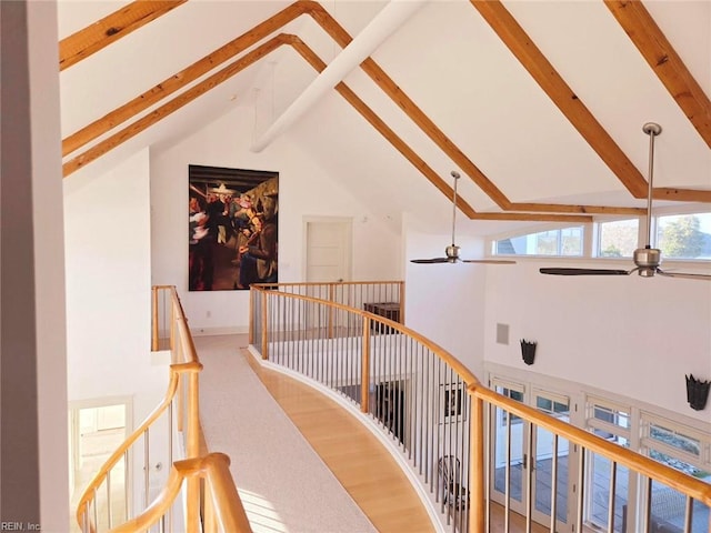 hall featuring beam ceiling and high vaulted ceiling