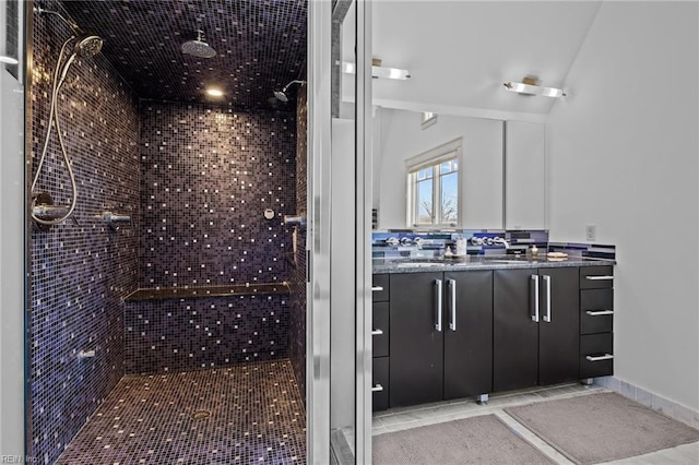 bathroom with tiled shower and vanity