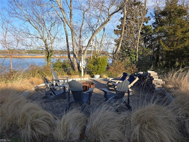 view of yard with a patio, a water view, and an outdoor fire pit