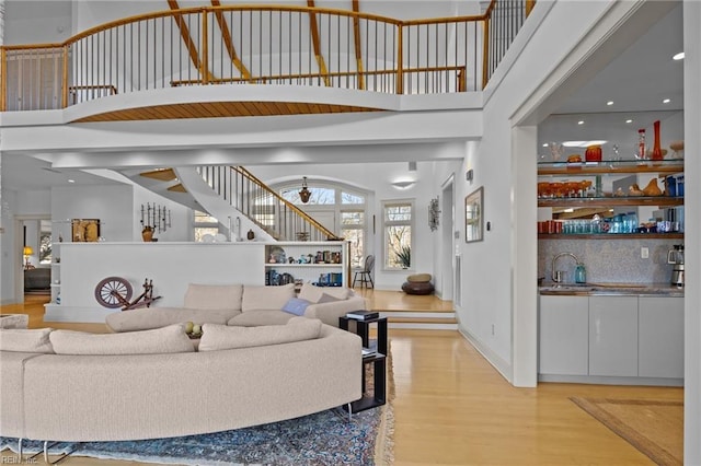 living room with a high ceiling and light hardwood / wood-style floors