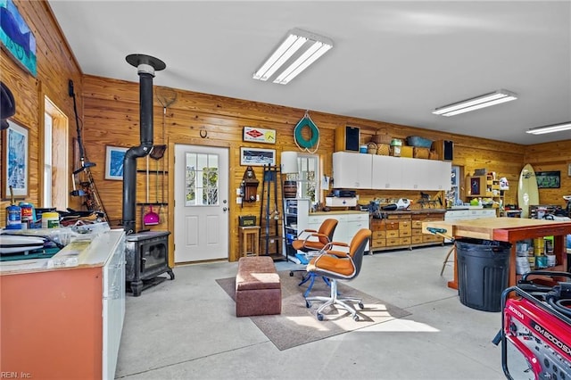 miscellaneous room featuring a workshop area, a wood stove, and wood walls