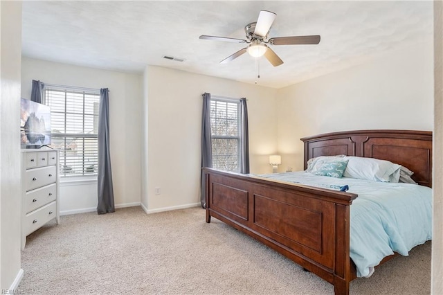 carpeted bedroom featuring multiple windows and ceiling fan