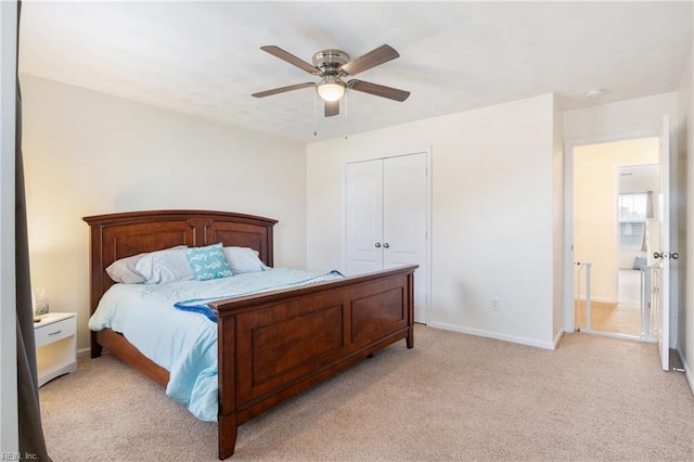 bedroom with a closet, light colored carpet, and ceiling fan