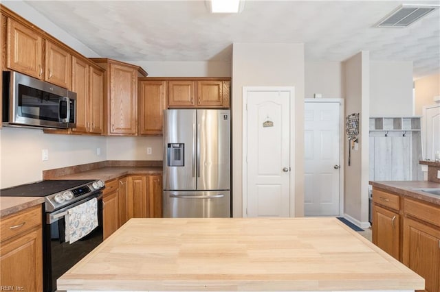 kitchen featuring butcher block counters and appliances with stainless steel finishes