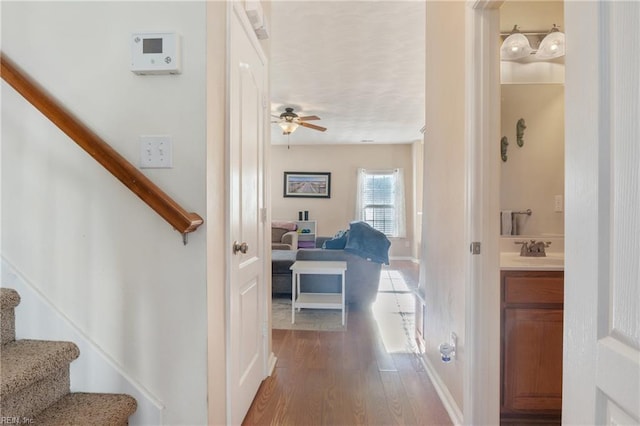 stairway with hardwood / wood-style floors, ceiling fan, and sink