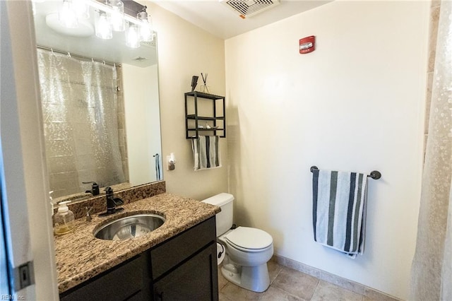 bathroom with tile patterned flooring, vanity, and toilet