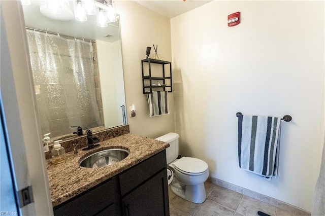 bathroom featuring tile patterned flooring, vanity, and toilet