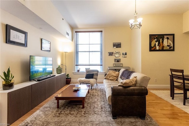 living room with hardwood / wood-style floors and an inviting chandelier