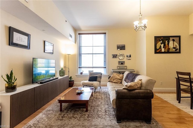 living room with light wood-type flooring and a chandelier