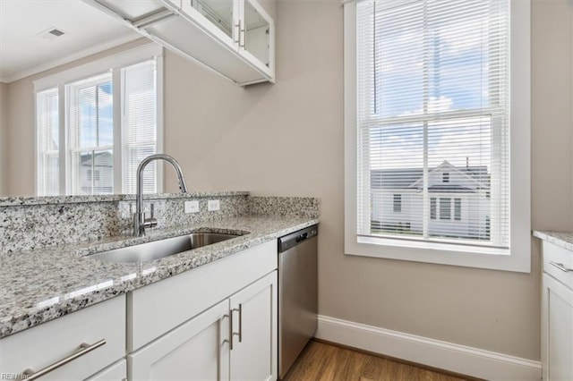 kitchen featuring dishwasher, sink, light hardwood / wood-style floors, light stone counters, and white cabinetry