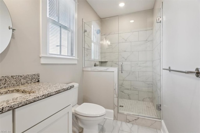 bathroom with a shower with door, vanity, and toilet