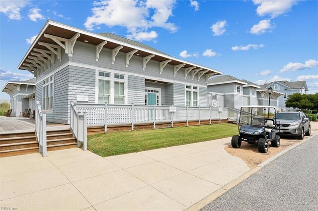 view of front facade featuring a front lawn and a wooden deck