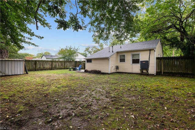 rear view of house featuring a storage unit and a lawn