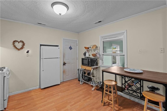 interior space featuring ornamental molding, a textured ceiling, and light wood-type flooring