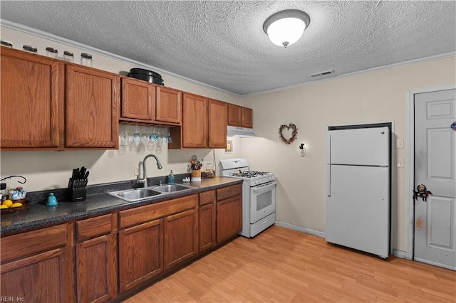 kitchen featuring a textured ceiling, crown molding, sink, and white appliances