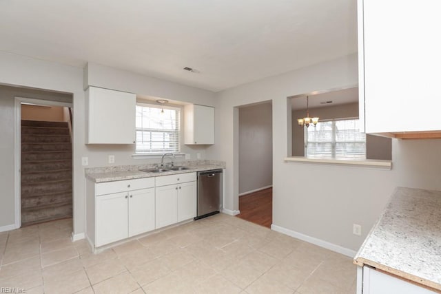 kitchen with dishwasher, sink, light tile patterned floors, an inviting chandelier, and white cabinets