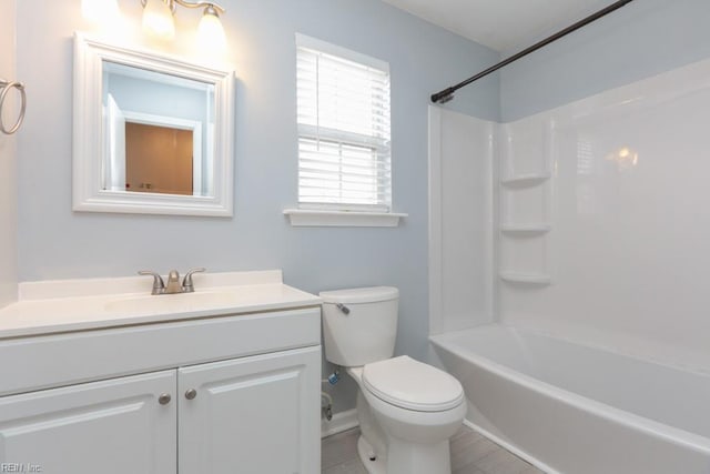 full bathroom featuring washtub / shower combination, vanity, and toilet