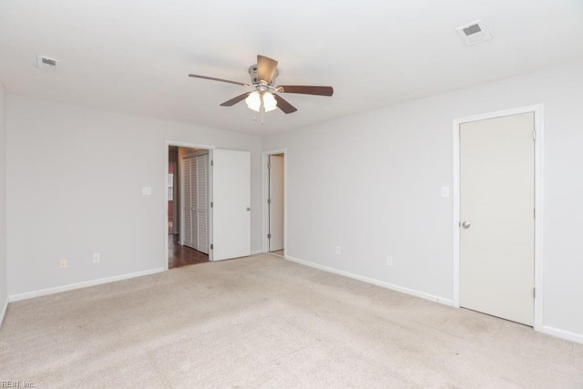 spare room with ceiling fan and light carpet