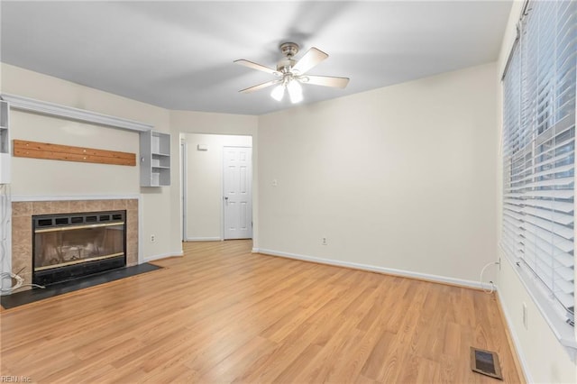 unfurnished living room featuring a fireplace, light hardwood / wood-style flooring, and ceiling fan