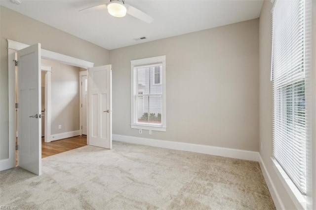 unfurnished bedroom with ceiling fan and light carpet