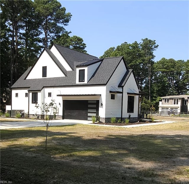 modern farmhouse style home with a front lawn and a garage