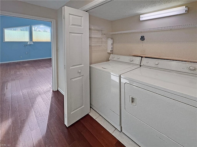 laundry area featuring dark hardwood / wood-style floors, a textured ceiling, and washing machine and clothes dryer