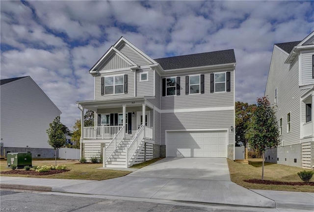 view of front of house with covered porch, a garage, and a front lawn