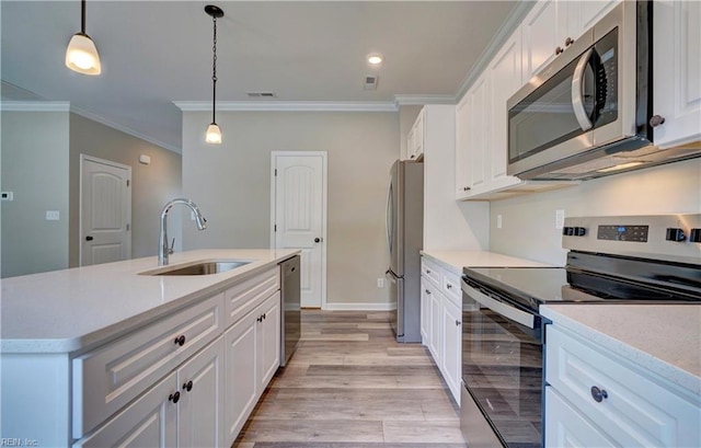 kitchen featuring white cabinets, appliances with stainless steel finishes, ornamental molding, and sink