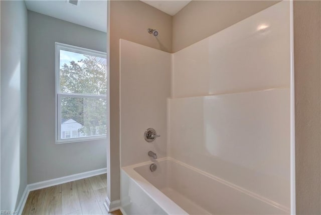 bathroom with hardwood / wood-style floors and tub / shower combination