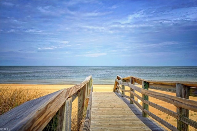 view of property's community featuring a water view and a beach view