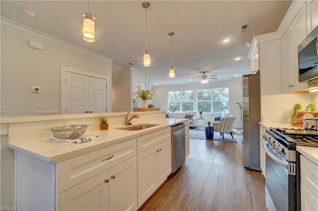 kitchen with pendant lighting, white cabinets, sink, ceiling fan, and appliances with stainless steel finishes