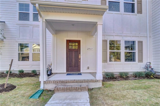 entrance to property featuring a lawn