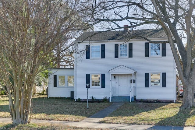 colonial-style house featuring a front yard