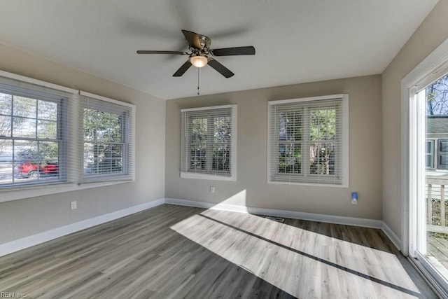 unfurnished sunroom featuring ceiling fan and a healthy amount of sunlight